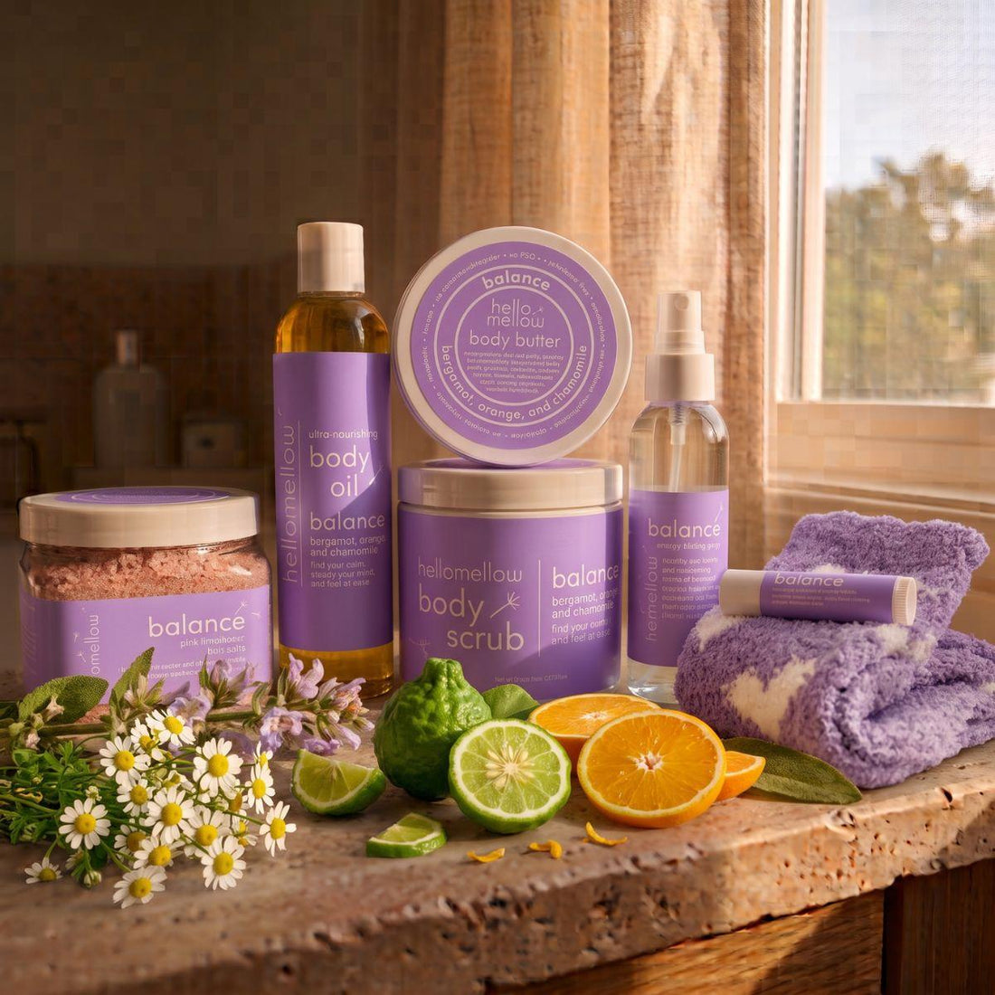 balance body scrub, body oil, and current butter products grouped together on a warm bathroom counter