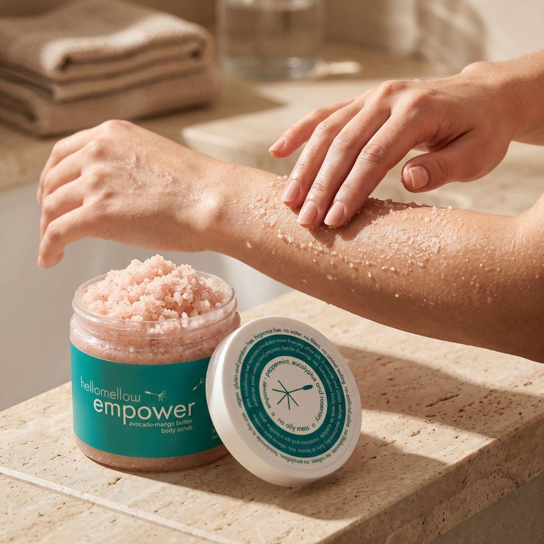 hands massaging empower body scrub onto damp skin in gentle circular motions