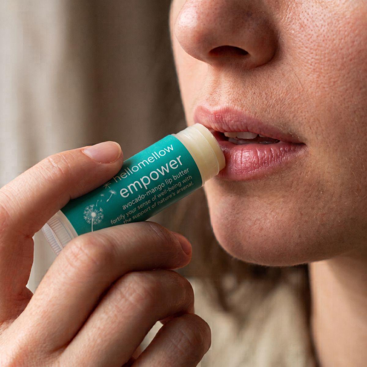 empower lip butter being applied naturally to lips in soft daylight