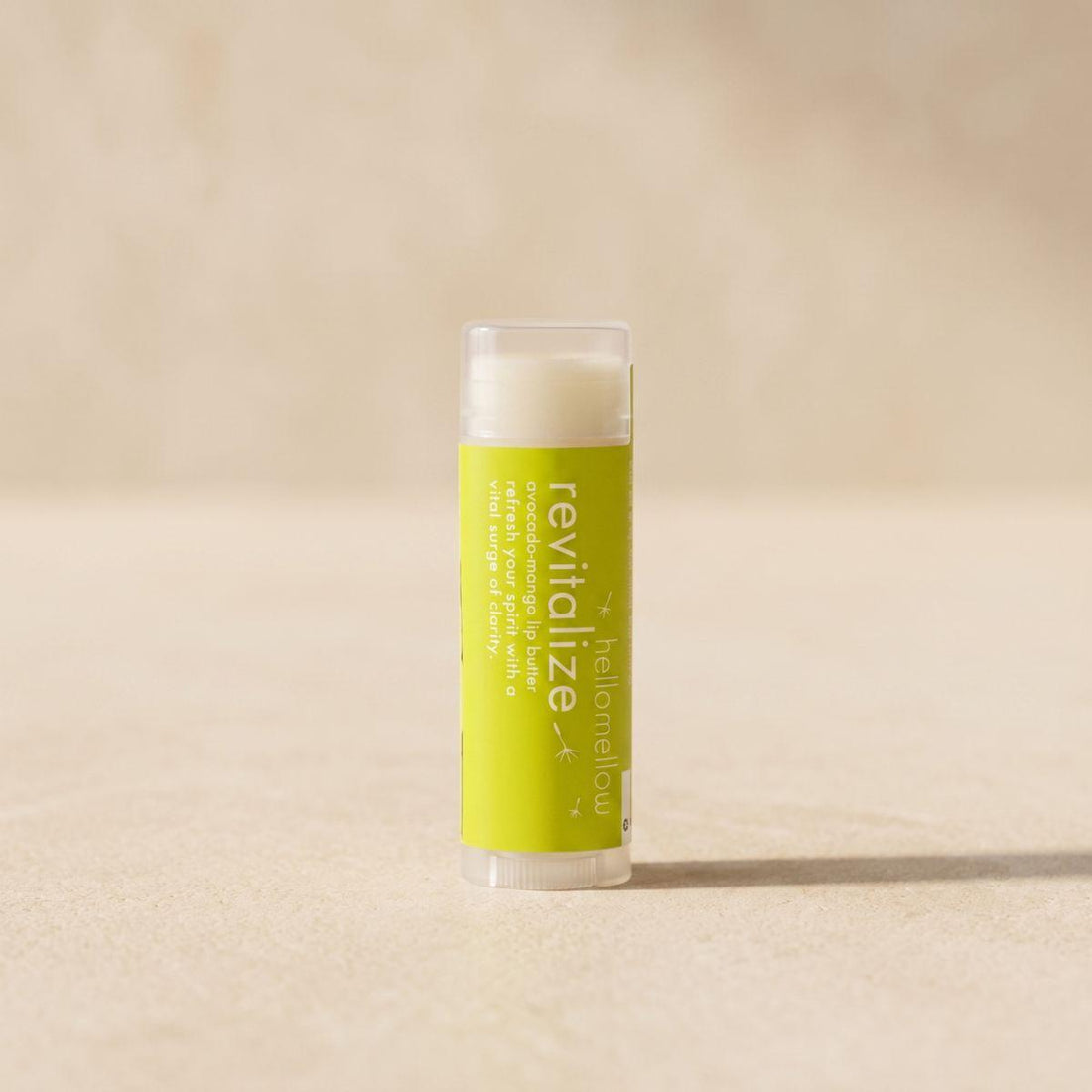 revitalize lip butter standing front-facing on a warm neutral surface