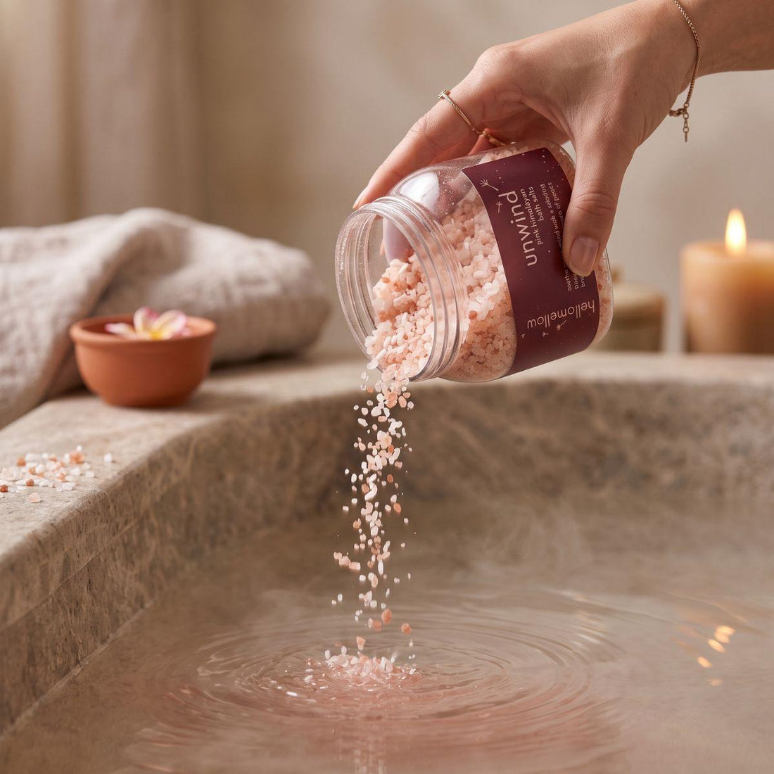 unwind bath salts being poured in a small amount toward warm bath water
