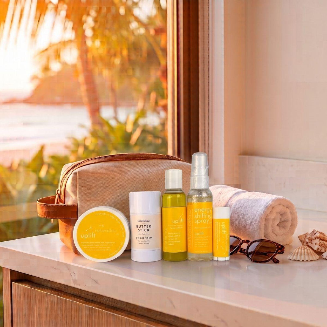the deluxe vacay vibe in uplift with a sunset background body scrub body butter stick body oil aromatherapy spray and lip butter