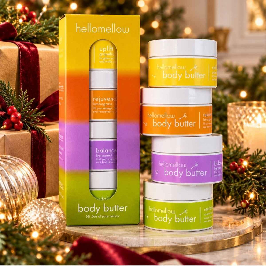 hellomellow bright days body butter try me set on a marble tray with holiday greenery and glowing candlelight.