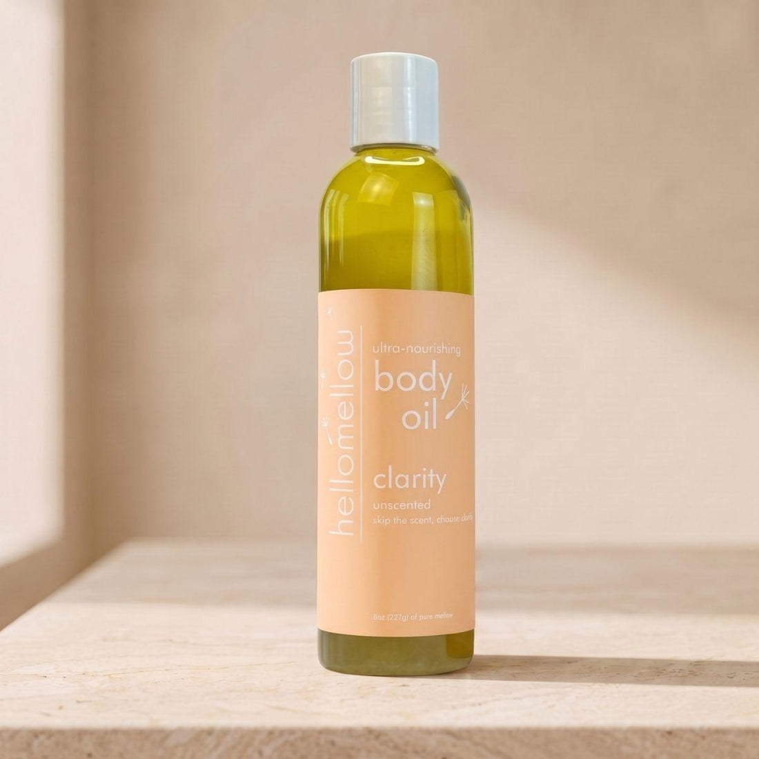 clarity body oil bottle standing front-facing on a warm neutral surface