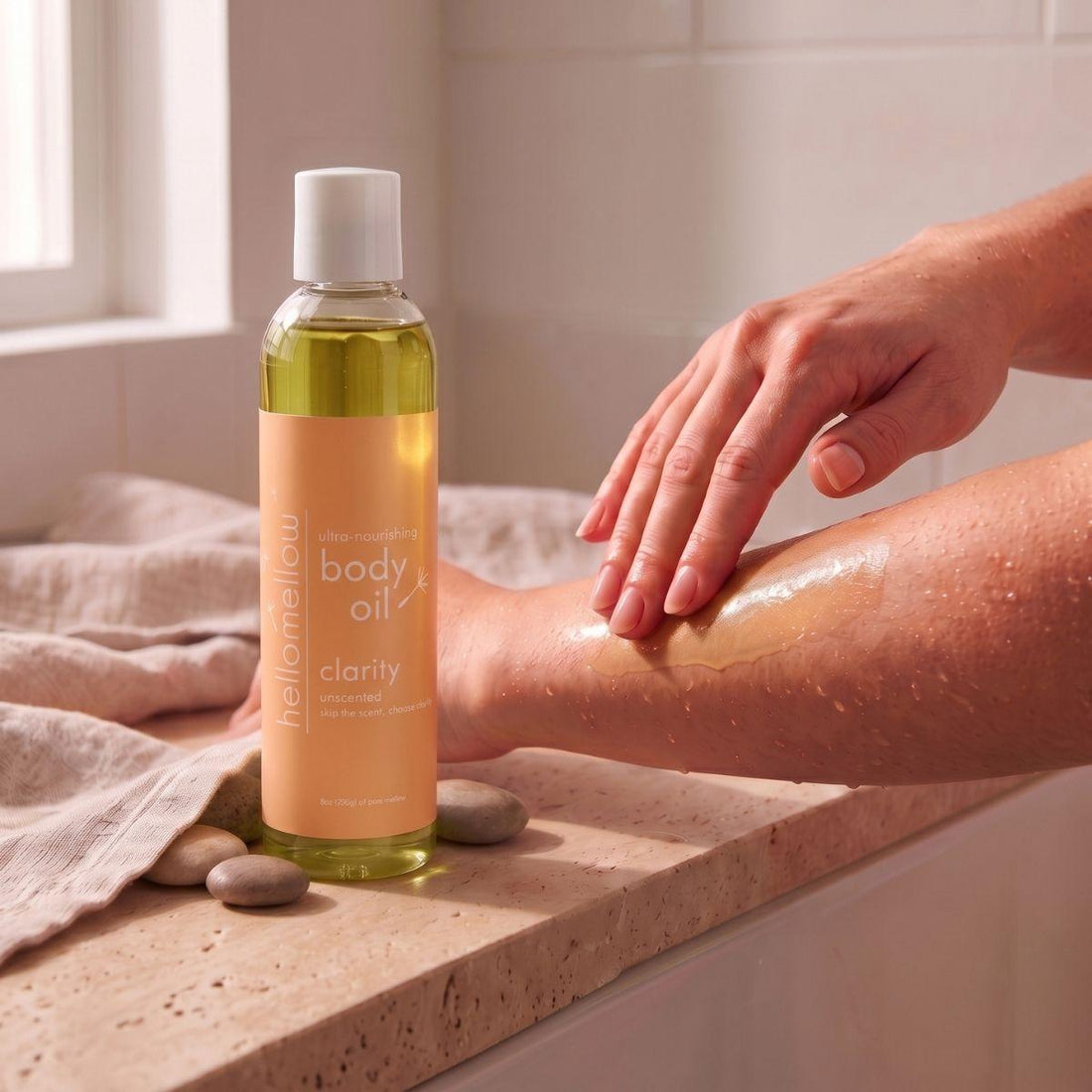 hands smoothing clarity body oil onto damp skin after a shower