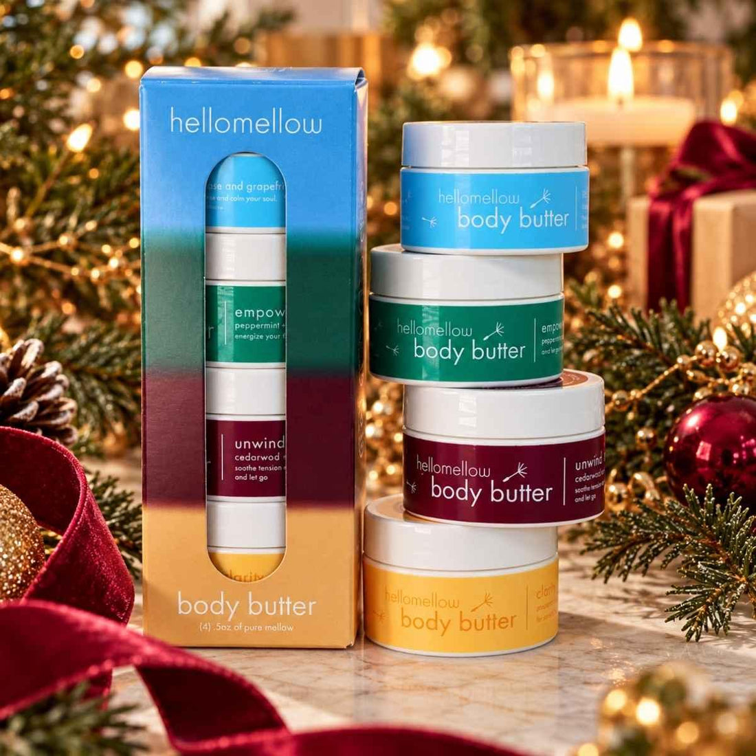 hellomellow deep breath body butter try me set with evergreen branches, burgundy ribbon and warm holiday lights.