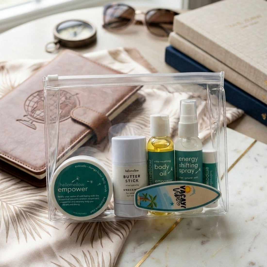 empower deluxe vacay vibe in clear travel bag mini body scrub, mini body oil, unscented butter stick, mini energy shifting spray, lip butter 