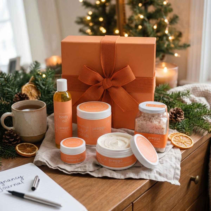 hellomellow preggo body-care gift set with five essentials, orange gift box, festive greenery and warm holiday lights.