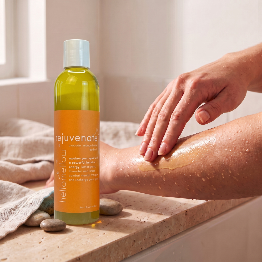 hands smoothing rejuvenate body oil onto damp skin after a shower