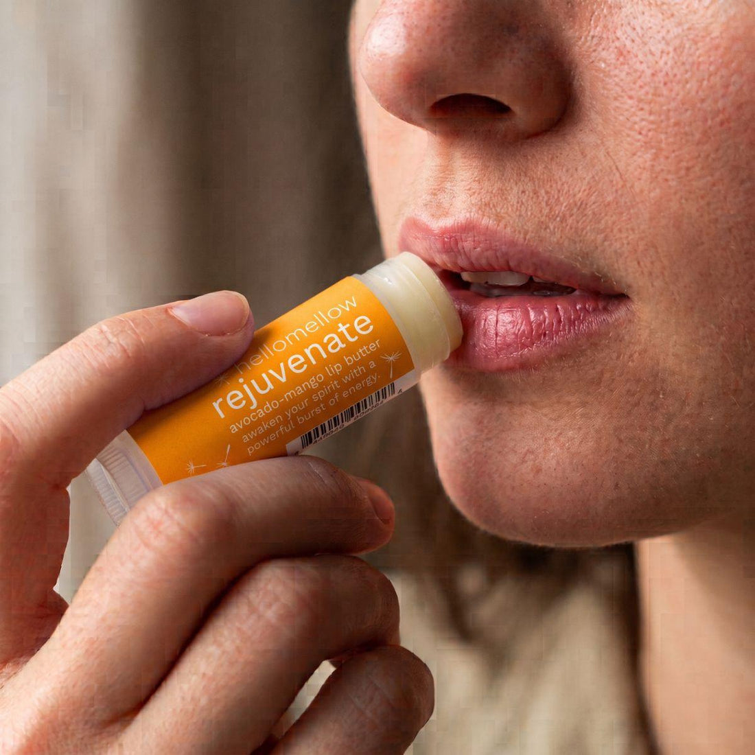 rejuvenate lip butter being applied naturally to lips in soft daylight