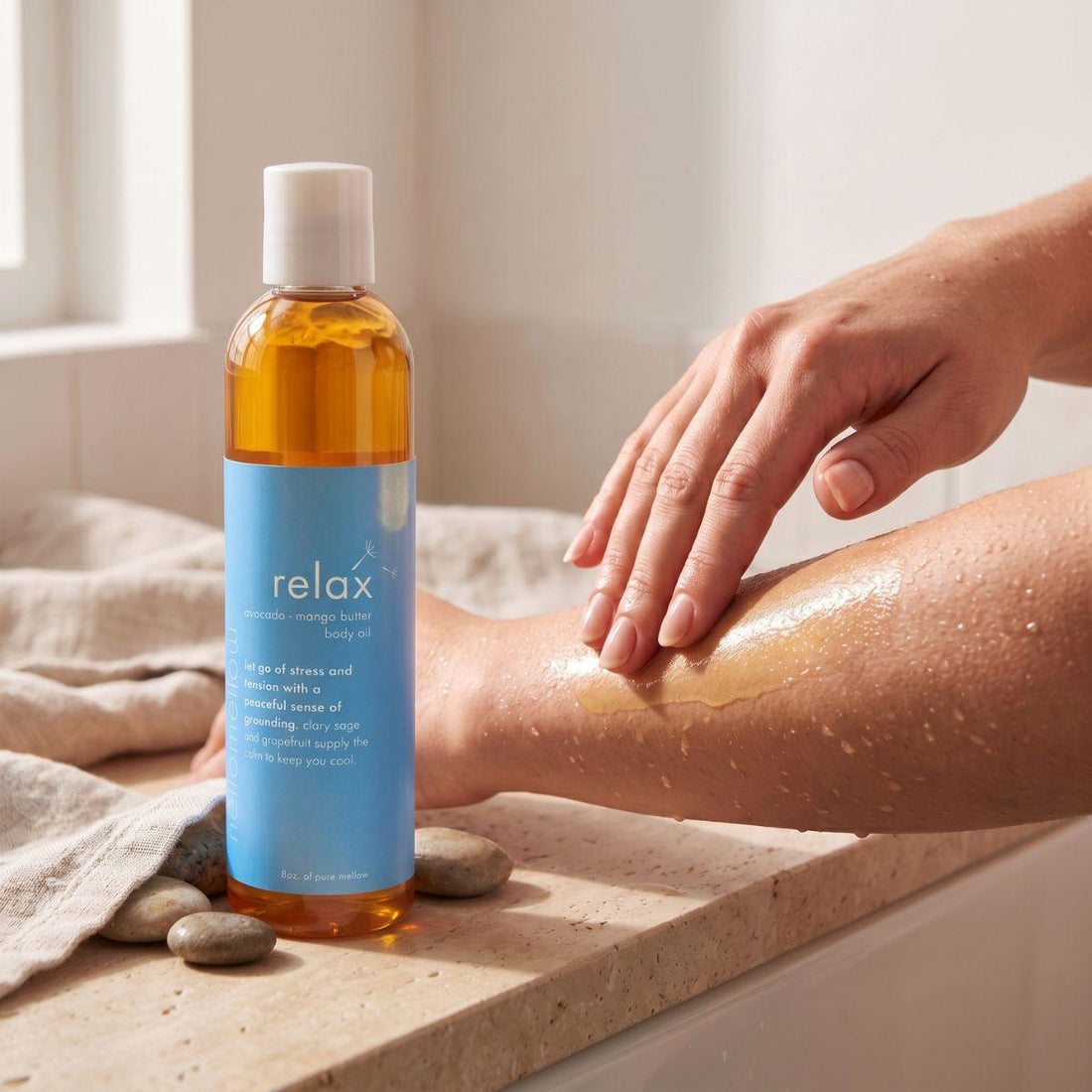 hands smoothing relax body oil onto damp skin after a shower