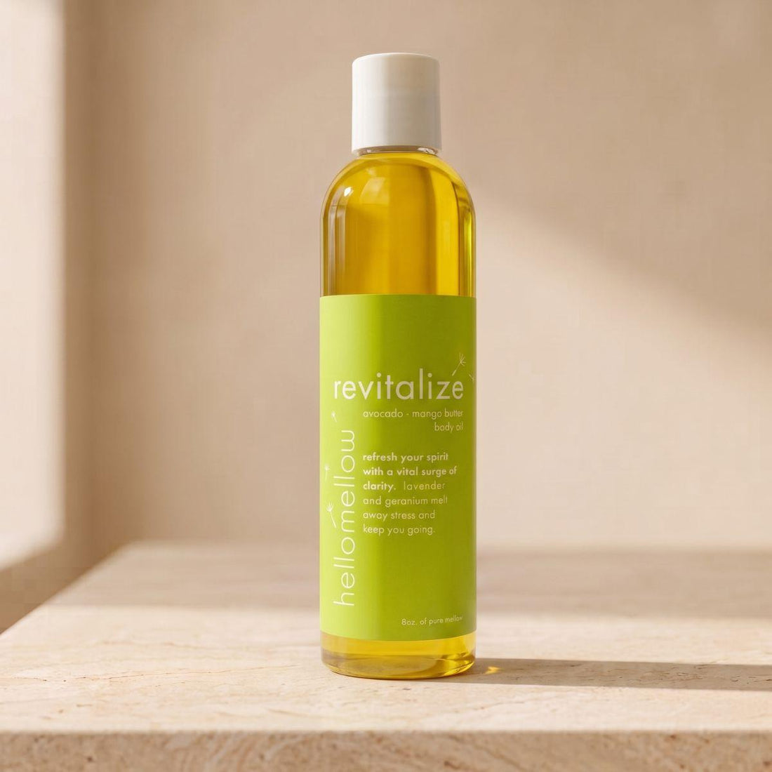 revitalize body oil bottle standing front-facing on a warm neutral surface