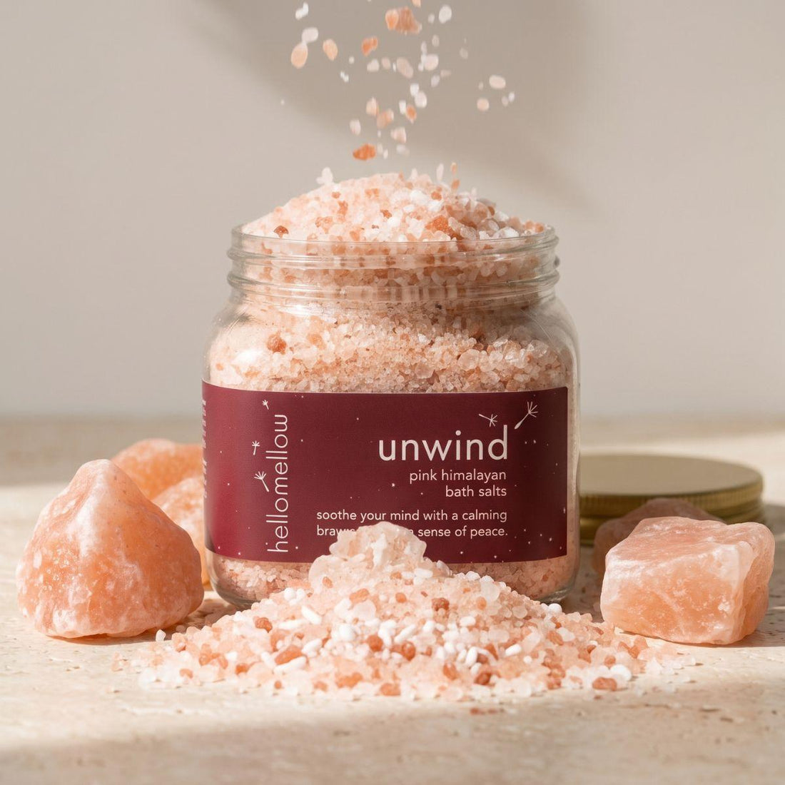 unwind bath salts jar standing front-facing on a warm neutral surface