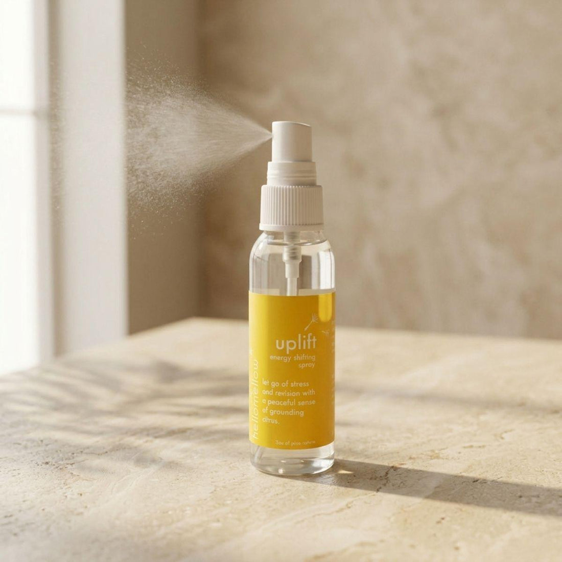uplift energy shifting spray bottle standing front-facing on a warm neutral surface